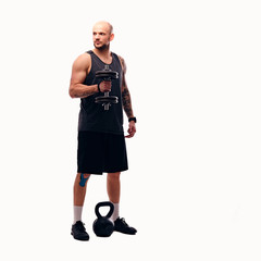Shaved head male holds dumbbell.