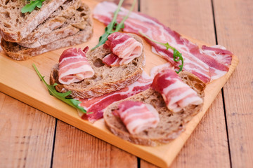 Bread with gourmet meat on a wooden desk.