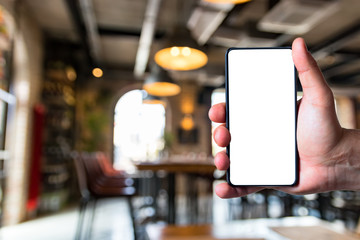 Man using bezel less smart phone in a restaurant.