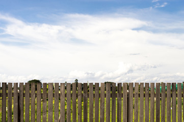 Wooden fence and cloudy sky background.