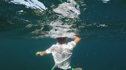 man sinking into the sea, half underwater close up, raw, 4k