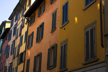 Fototapeta na wymiar Many windows. Medieval facade. Window shutters. Architectural style of Italy