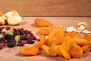 Mix of different dried fruits on wooden background. Healthy raw organic snack