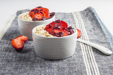 Yogurt with oat flake and fresh berries for healthy morning meal put on white wood background, Breakfast set.