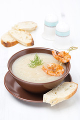 Potato cream soup with glazed shrimp and bread