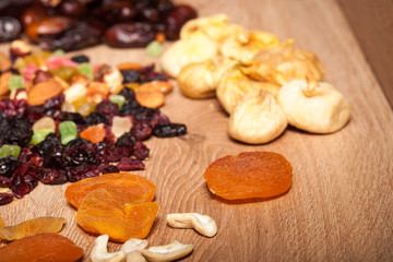 Fototapeta premium Mix of different dried fruits on wooden background. Healthy raw organic snack