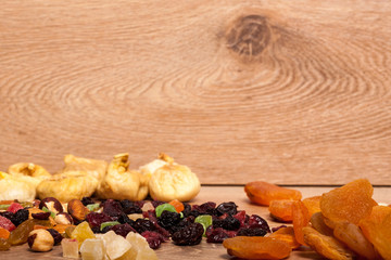 Mix of different dried fruits on wooden background. Healthy raw organic snack