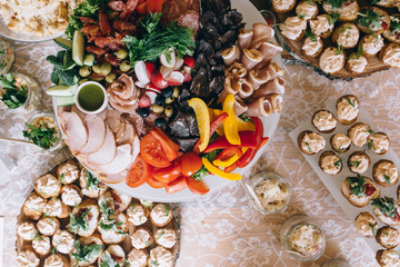 Italian antipasti wine snacks set. Brushettas, cheese variety, Mediterranean olives, pickles, Prosciutto di Parma with melon, salami and wine in glasses over black grunge background, top view