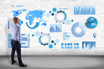 Businessman in front of a wall thinking about a business graph and chart interface - business...