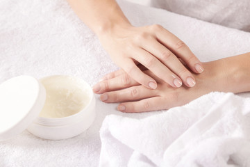 Obraz na płótnie Canvas Closeup of female hands applying cream