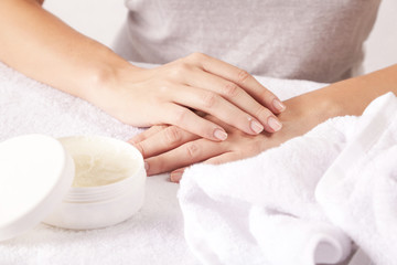 Closeup of female hands applying cream