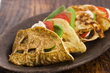 Pancakes sutffed with ham, cheese, tomatoes and spinach