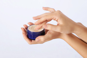 Closeup of female hands applying cream