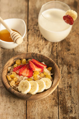 oatmeal porridge with strawberry and banana in wood bowl