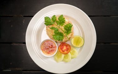 Thai Healthy food : fried rice chicken with egg and green coriander leaves and side dish.  (Asian fried rice) view from above on dark wood.