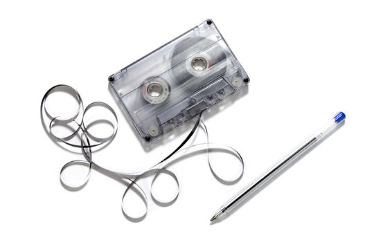 Retro cassette with loose tape over a white background    