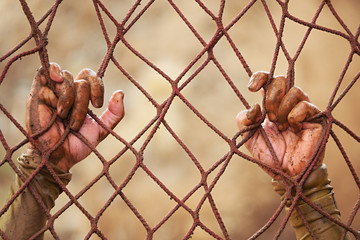 Mud race runners,man and climbing a net hand detail