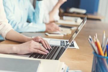 Youthful woman working via modern gadget in office