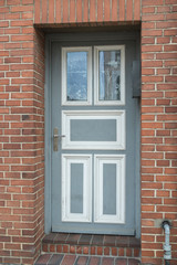 Fototapeta na wymiar Grau weiße Haustür eines Hauses