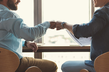 Obraz premium Youthful guys communicating together while working in office