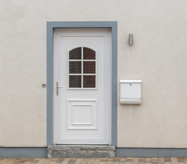 Weiße Haustür eines Hauses mit Briefkasten