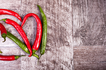 Spicy pepper on wooden background. Over top view. Chilli and hot