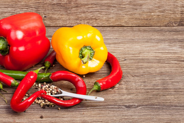 Spicy and sweet pepper on wooden background in studio photo. Healthy eating
