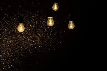 light bulbs on a black background with sparkles