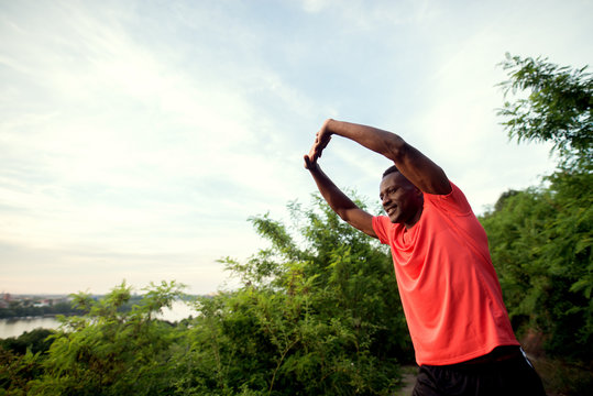 Young african american man stretching outdoor in the morning.