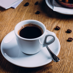 Cup of Coffee and Beans on Wooden Table Background. Copy space. Breakfast cafe concept