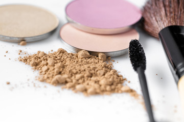 Obraz na płótnie Canvas Mascara, beige powder for face, eye shadow and makeup brush on white background