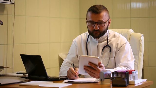 Doctor working in the office and smiling to the camera
