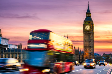 Big Ben with the Houses of Parliament and a red double-decker bus passing at dusk