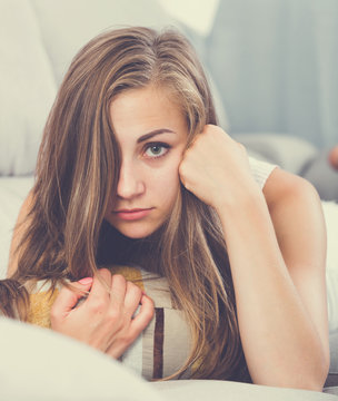 Offended Girl Lying On Sofa With Pillow