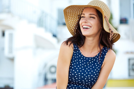 Smiling beautiful young woman in summer hat