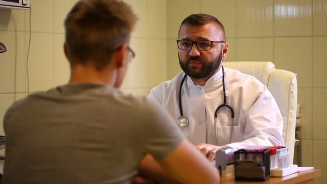 Doctor speaking on cellphone and tells bad news to the patient
