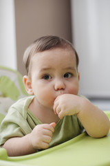 Thoughtful little baby boy eating