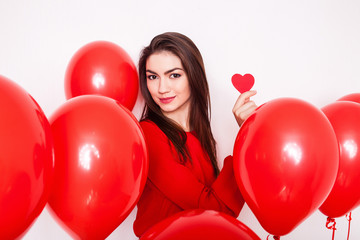 Beautiful brunette girl holds Paper red heart on a white background