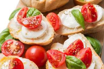 Bruschette con mozzarella, pomodoro fresco, olio di oliva, basilico e origano