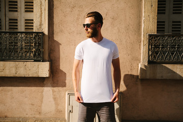 Hipster handsome male model with beard  wearing white blank  t-shirt with space for your logo or...