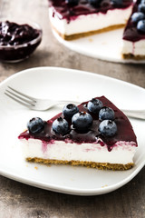 Piece of blueberry cheesecake on wooden table
