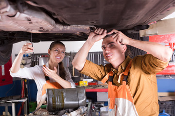 Obraz na płótnie Canvas Two mechanics repairing car