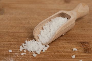 Thick sea salt on a wooden spoon for spices - obrazy, fototapety, plakaty
