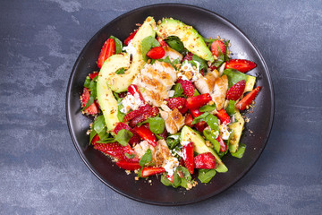Strawberry, avocado, spinach salad with chicken. View from above, top studio shot