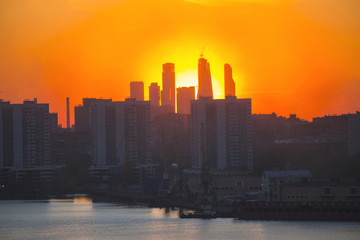 Fototapeta premium Sunrise at the city. Silhouette of buildings.