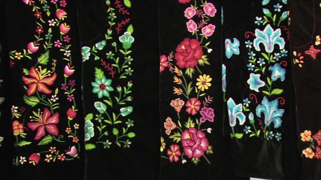 Display of Large Hand Crafted Mexican Blankets/Fabrics With a Multicolored Floral Print 