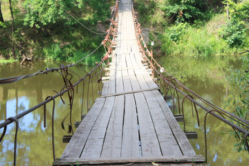 Summer landscape. Suspension bridge across the river. Russia 