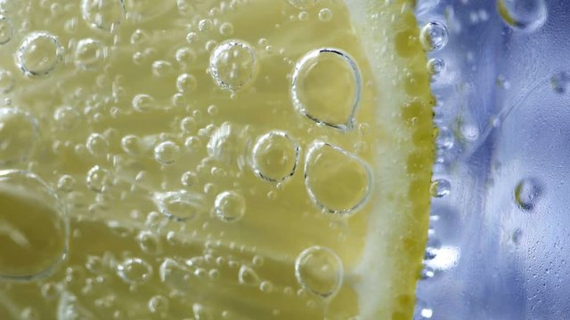 Macro close up slice lemon, ice cubes and bubble float soda water, UHD 4k 3840x2160.
