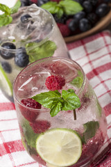 Summer cold drinks with raspberries, blackberries and blueberries on white background