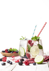 Summer cold drinks with raspberries, blackberries and blueberries on white background